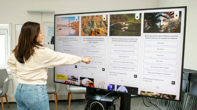 a woman pointing to a poster on a wall